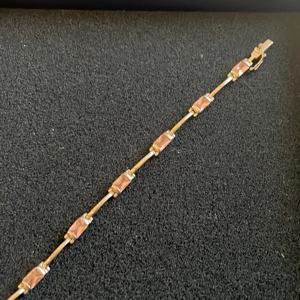 7 inch bracelet with pink stones. Silver plated in between stones.